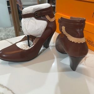 Sexy bootie style heel. Ankle strapped with a tan detail .